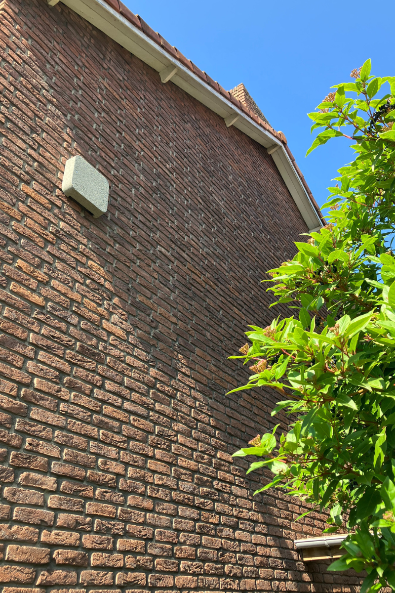 Geïsoleerde zijmuur van woning met vleermuiskastjes voor natuurvriendelijke isolatie.